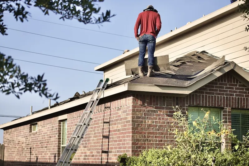 Professional roofer working on a residential roof in Goodley Manor